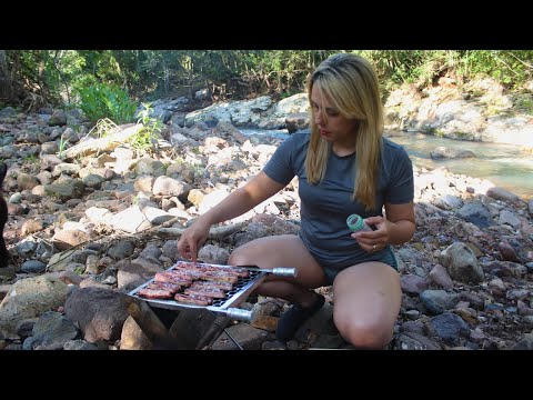 BRAZILIAN BARBECUE - Brazilian girl relaxing by the river and preparing a delicious snack